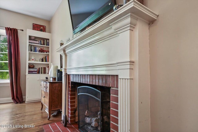 detailed view of a brick fireplace and wood finished floors
