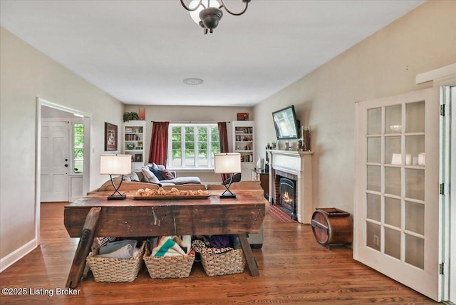 living room featuring wood finished floors and a lit fireplace