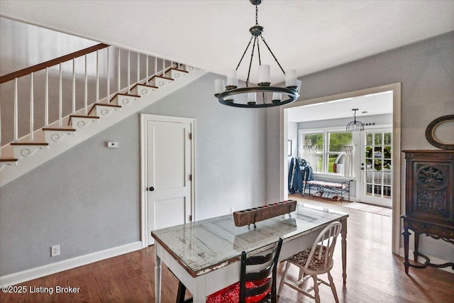 dining space featuring a chandelier, wood finished floors, stairway, and baseboards