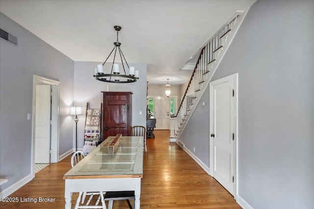 entryway with stairs, baseboards, light wood-style flooring, and a chandelier
