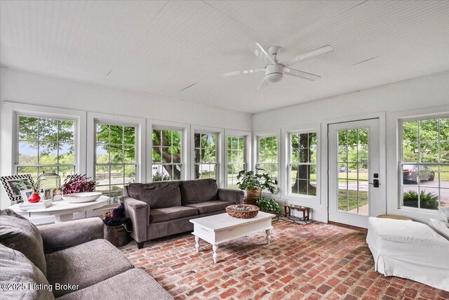 sunroom featuring french doors, healthy amount of natural light, and brick flooring