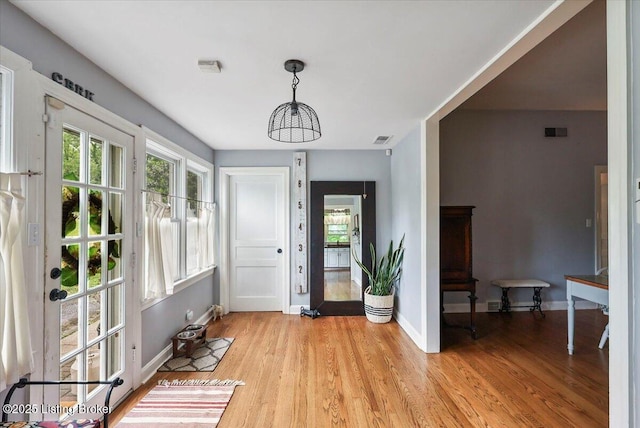 foyer with light wood-type flooring and baseboards