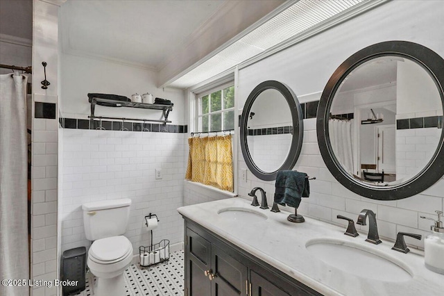 full bath featuring tile walls, crown molding, toilet, and double vanity