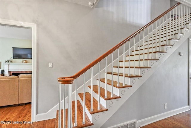 stairs featuring wood finished floors and baseboards