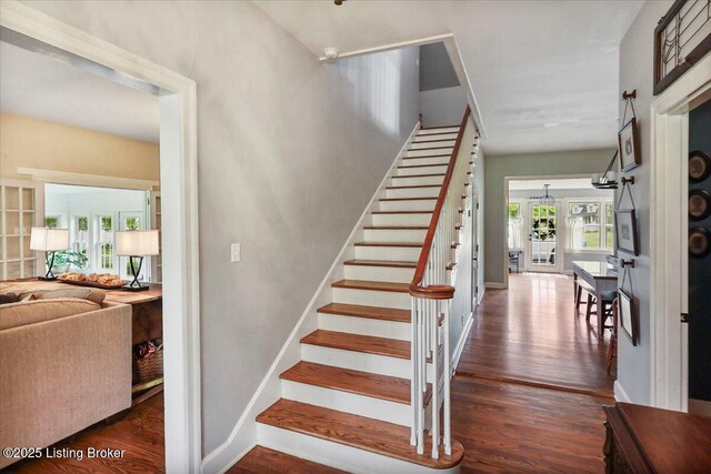 staircase featuring wood finished floors and baseboards