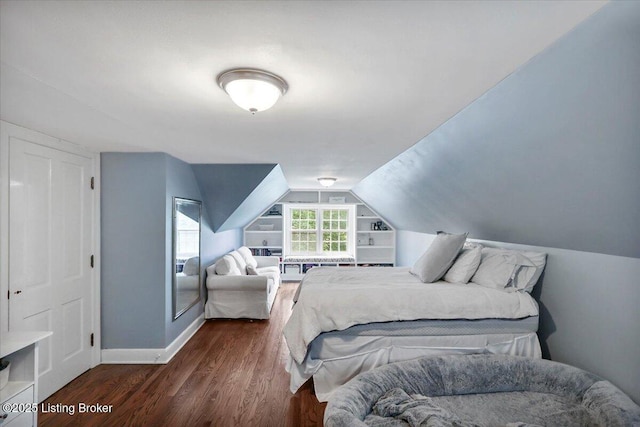 bedroom featuring dark wood-type flooring, baseboards, and vaulted ceiling