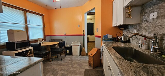 1766 Wilart Dr, Louisville, KY 40210 - kitchen featuring a sink, stainless steel microwave, white cabinetry, and stone countertops