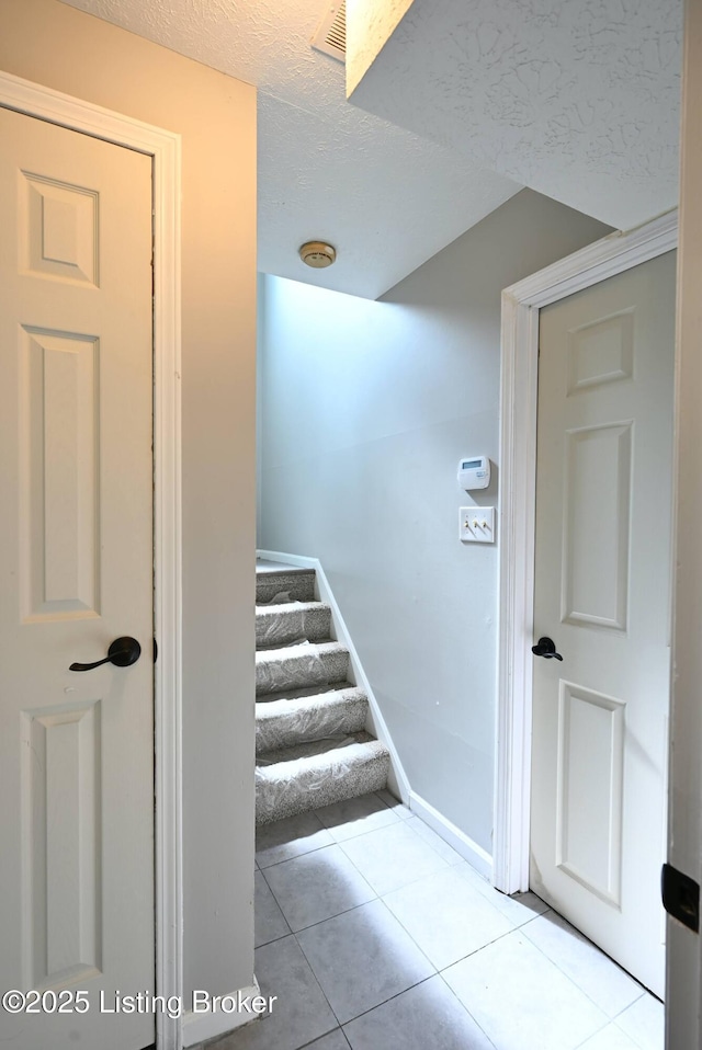 4433 Malcolm Rd, Louisville, KY 40216 - stairway featuring tile patterned flooring, a textured ceiling, and baseboards