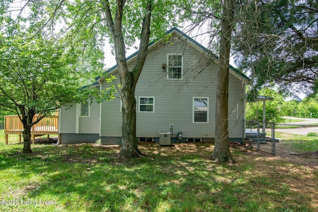 back of house featuring cooling unit and a wooden deck