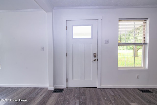 entrance foyer with dark wood-style flooring, baseboards, ornamental molding, and plenty of natural light