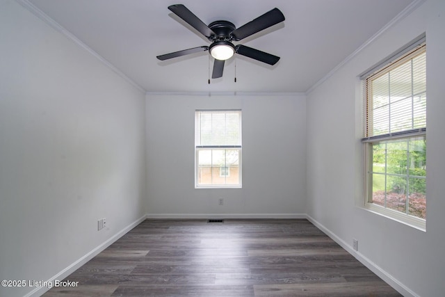 spare room featuring healthy amount of natural light, ornamental molding, a ceiling fan, dark wood-type flooring, and baseboards