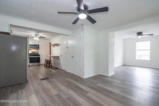 living room featuring ceiling fan, wood finished floors, crown molding, baseboards, and a textured ceiling
