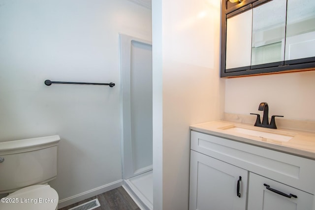 full bath with vanity, wood finished floors, toilet, a shower stall, and baseboards