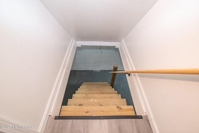 stairway featuring wood finished floors and baseboards