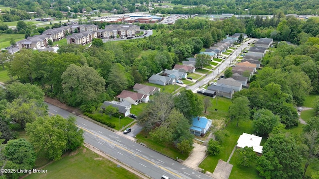 aerial overview of property's location featuring nearby suburban area and a tree filled landscape
