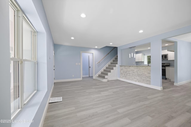 5319 New Cut Rd, Louisville, KY 40214 - unfurnished living room featuring baseboards, stairs, light wood finished floors, and recessed lighting