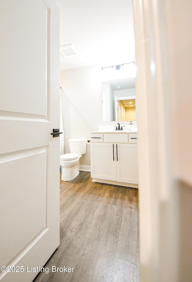 9206 Fox Chase Rd, Louisville, KY 40228 - half bathroom with vanity, wood finished floors, toilet, and baseboards
