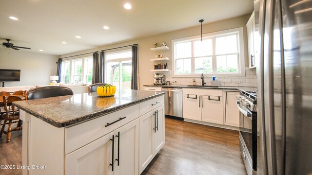 9206 Fox Chase Rd, Louisville, KY 40228 - kitchen with appliances with stainless steel finishes, a sink, recessed lighting, a kitchen island, and dark stone counters