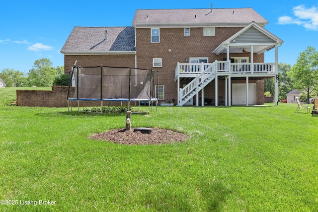 4026 Old Farm Dr, Crestwood, KY 40014 - back of property with a trampoline, a ceiling fan, brick siding, a lawn, and a wooden deck