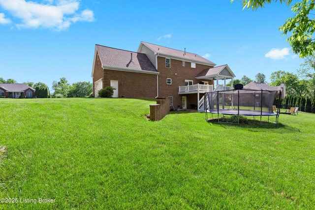 4026 Old Farm Dr, Crestwood, KY 40014 - back of house with a trampoline, a lawn, brick siding, and a wooden deck