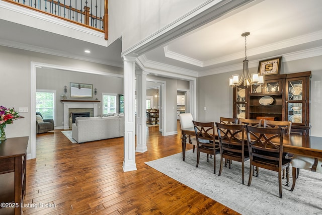 13412 Hampton Cir, Goshen, KY 40026 - dining room featuring a fireplace, ornamental molding, hardwood / wood-style floors, a chandelier, and decorative columns