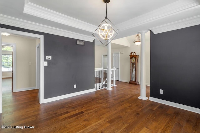 unfurnished room with wood finished floors, crown molding, baseboards, ornate columns, and a chandelier