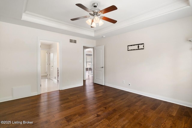 unfurnished bedroom with a raised ceiling, crown molding, wood finished floors, baseboards, and ceiling fan