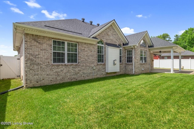 rear view of property featuring a ceiling fan, brick siding, a patio area, and a shingled roof