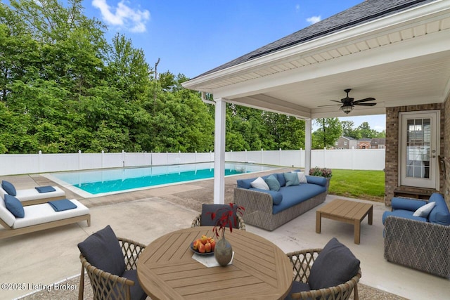 view of swimming pool with an outdoor living space, a patio area, a fenced backyard, and ceiling fan