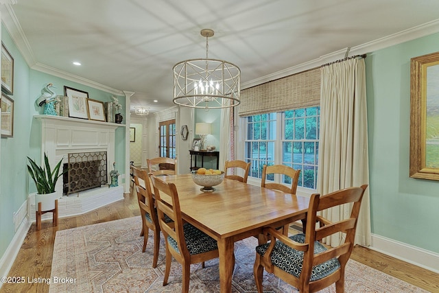801 Shady Ln, Anchorage, KY 40223 - dining room with crown molding, baseboards, a chandelier, wood finished floors, and a fireplace with raised hearth