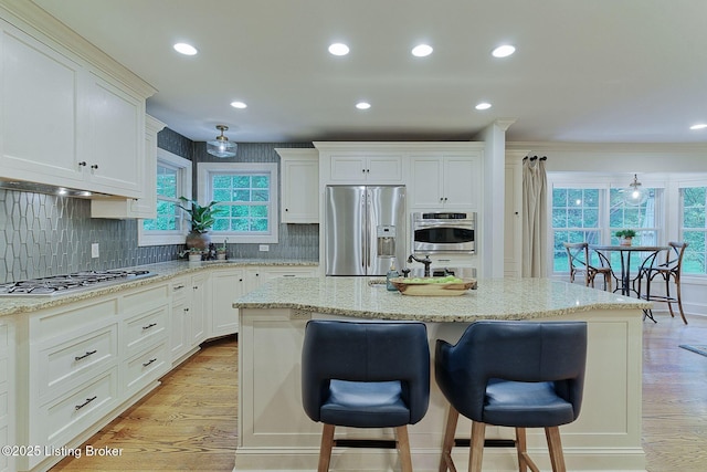 801 Shady Ln, Anchorage, KY 40223 - kitchen with appliances with stainless steel finishes, a kitchen bar, light wood finished floors, white cabinetry, and recessed lighting