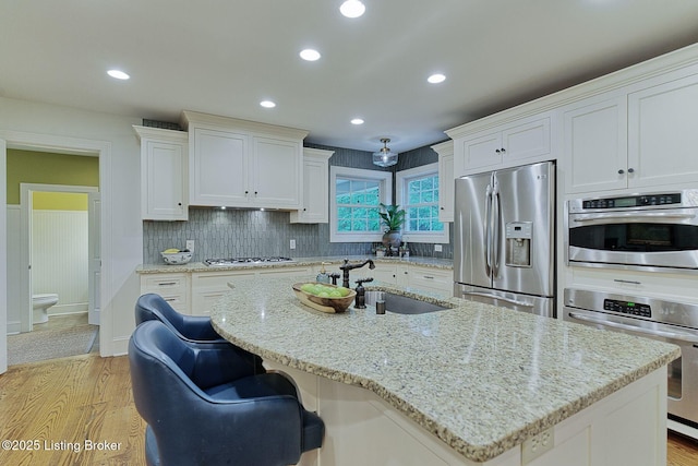 801 Shady Ln, Anchorage, KY 40223 - kitchen with appliances with stainless steel finishes, a sink, light wood-type flooring, white cabinetry, and recessed lighting