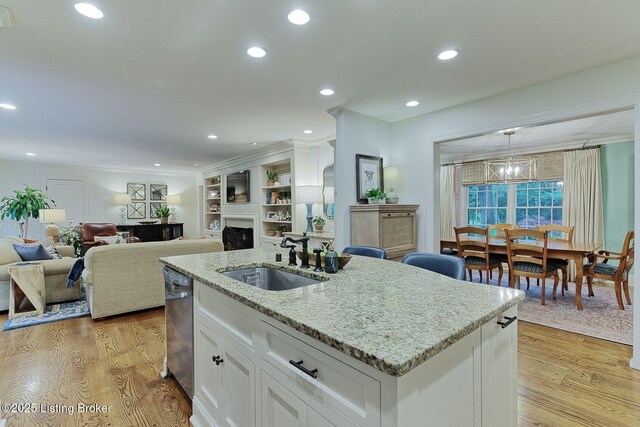 801 Shady Ln, Anchorage, KY 40223 - kitchen with a sink, white cabinetry, a kitchen island with sink, stainless steel dishwasher, and a fireplace