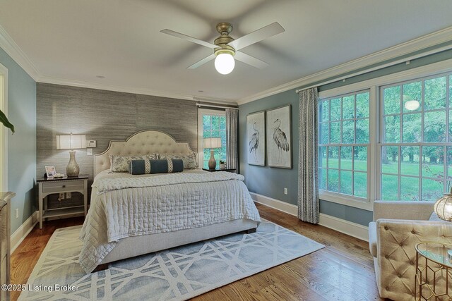 801 Shady Ln, Anchorage, KY 40223 - bedroom featuring multiple windows, baseboards, an accent wall, crown molding, and wood finished floors