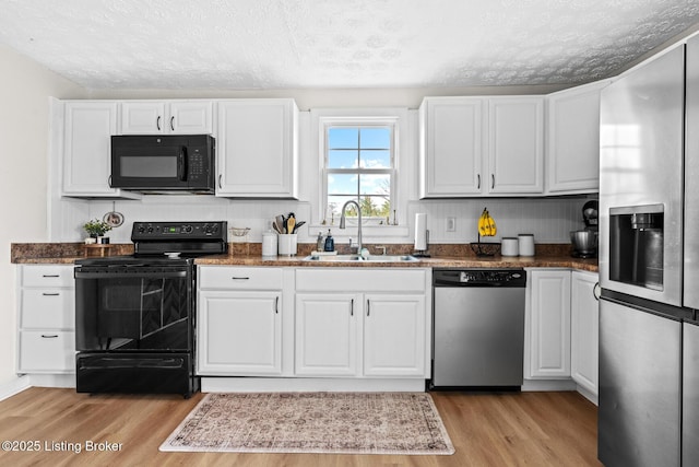 224 Murphy Ln, Bloomfield, KY 40008 - kitchen with black appliances, a sink, a textured ceiling, light wood finished floors, and white cabinetry