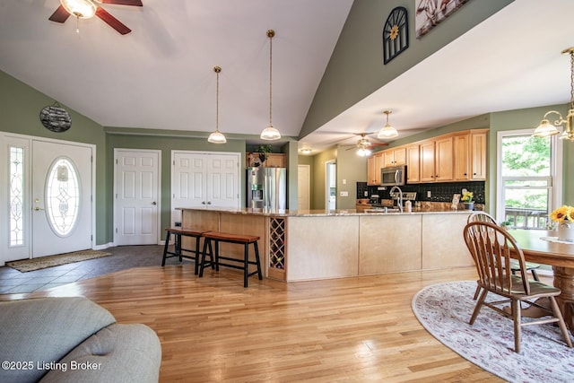 79 Ivy Ct, Brandenburg, KY 40108 - dining area featuring ceiling fan, high vaulted ceiling, light wood-type flooring, and a chandelier
