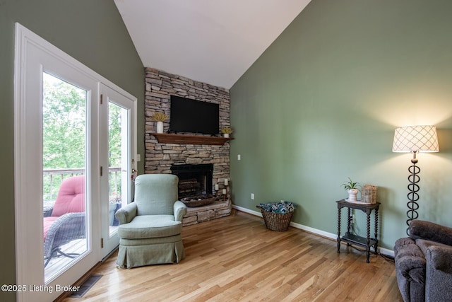 79 Ivy Ct, Brandenburg, KY 40108 - living room featuring high vaulted ceiling, a stone fireplace, light wood-style floors, and baseboards