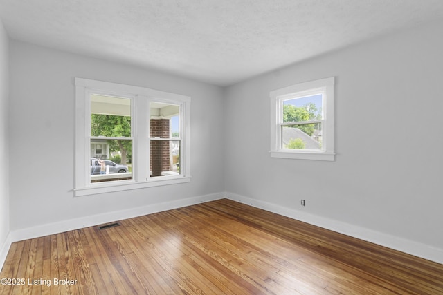 1011 Wetterau Ave, Louisville, KY 40217 - unfurnished room with plenty of natural light, baseboards, hardwood / wood-style floors, and a textured ceiling