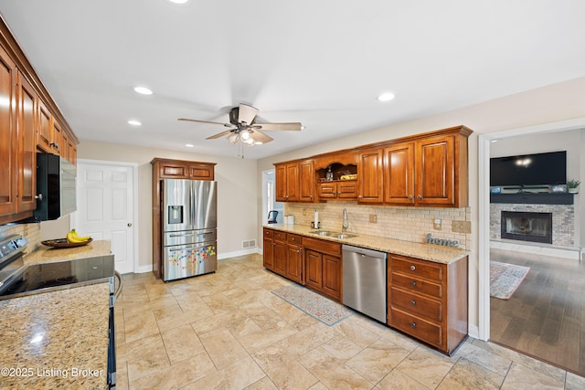 4424 Grand Cir, Crestwood, KY 40014 - kitchen featuring stainless steel appliances, a sink, baseboards, a ceiling fan, and a fireplace