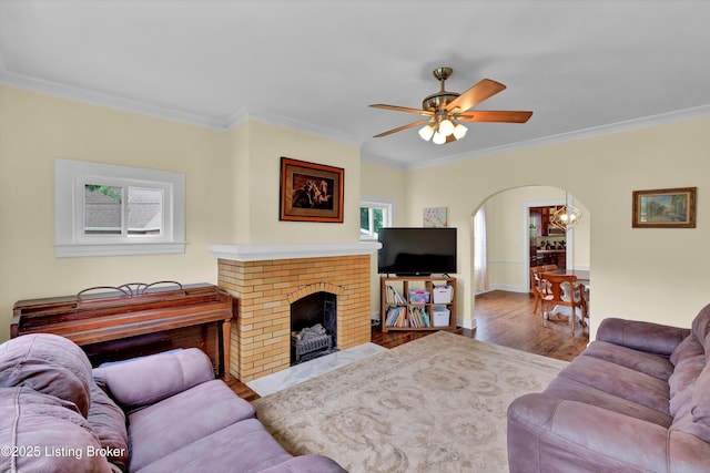 1433 Indiana Ave, Louisville, KY 40213 - living area featuring arched walkways, ornamental molding, wood finished floors, a ceiling fan, and a brick fireplace