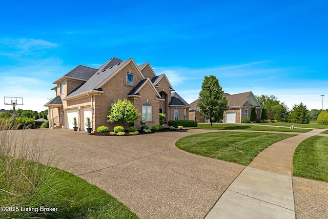 view of front of house with brick siding, curved driveway, a front yard, roof with shingles, and an attached garage