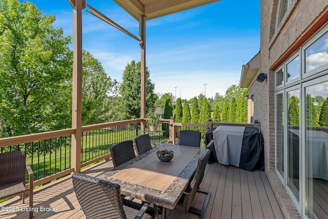 wooden terrace with a grill and outdoor dining area