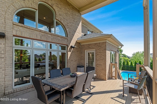 wooden deck featuring an outdoor pool and outdoor dining space