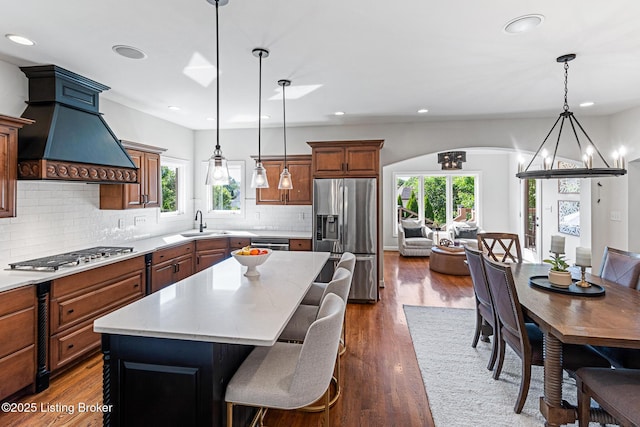 kitchen with stainless steel appliances, custom exhaust hood, a chandelier, healthy amount of natural light, and recessed lighting