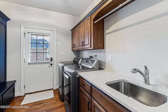 washroom featuring cabinet space, washing machine and dryer, and dark wood-style floors