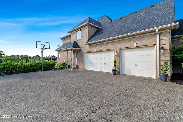 view of front facade featuring driveway, brick siding, a shingled roof, and an attached garage