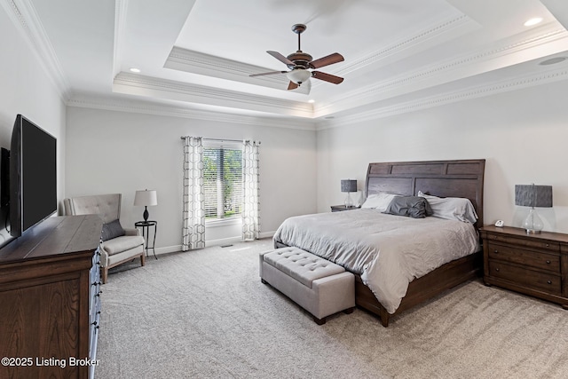 bedroom featuring light carpet, crown molding, a tray ceiling, baseboards, and a ceiling fan