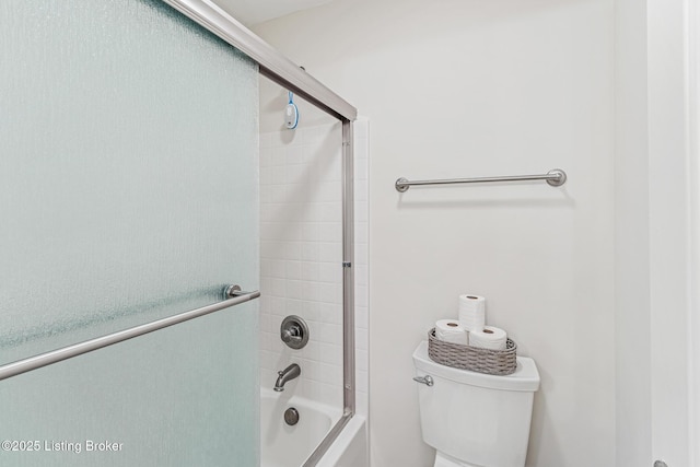 bathroom with combined bath / shower with glass door and toilet