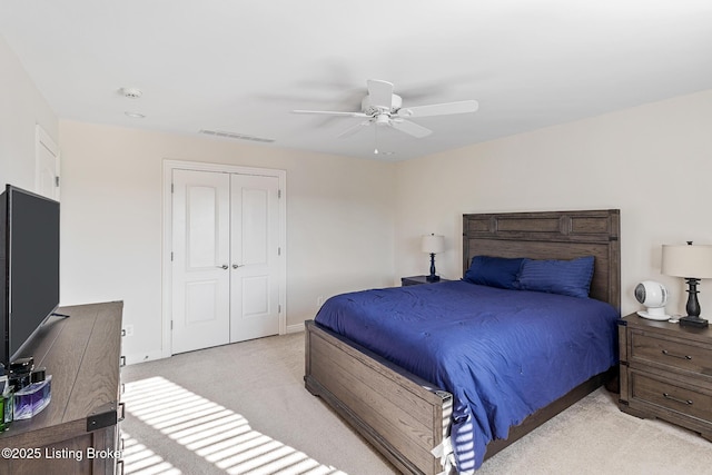 bedroom with light colored carpet, a closet, and ceiling fan
