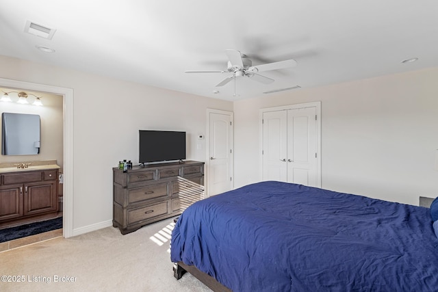 bedroom with light carpet, connected bathroom, baseboards, a closet, and ceiling fan